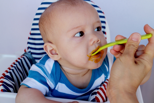 feeding a baby smooth textured food.